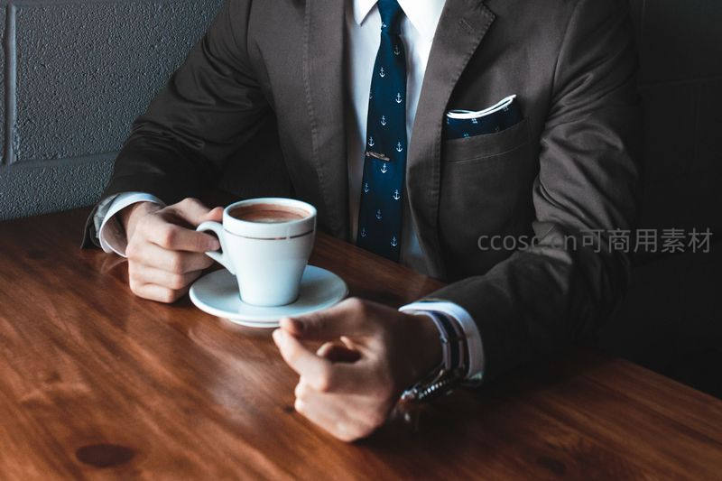 商务男士手握咖啡杯静享午后时光