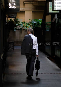 背影行走在商业巷道的上班族