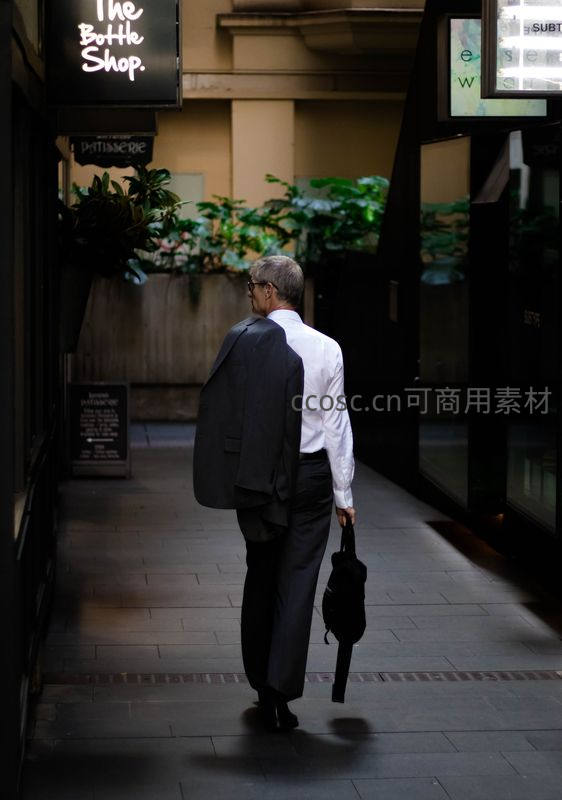 背影行走在商业巷道的上班族
