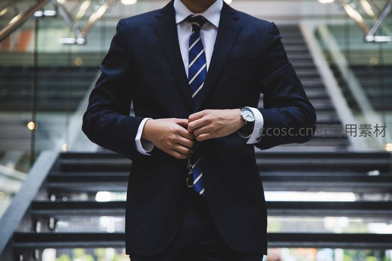 西装革履的男士在楼梯间整理衣领