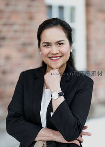 微笑女商人砖墙前摆姿