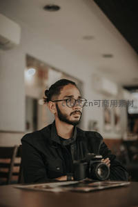 戴眼镜的摄影师在咖啡馆沉思