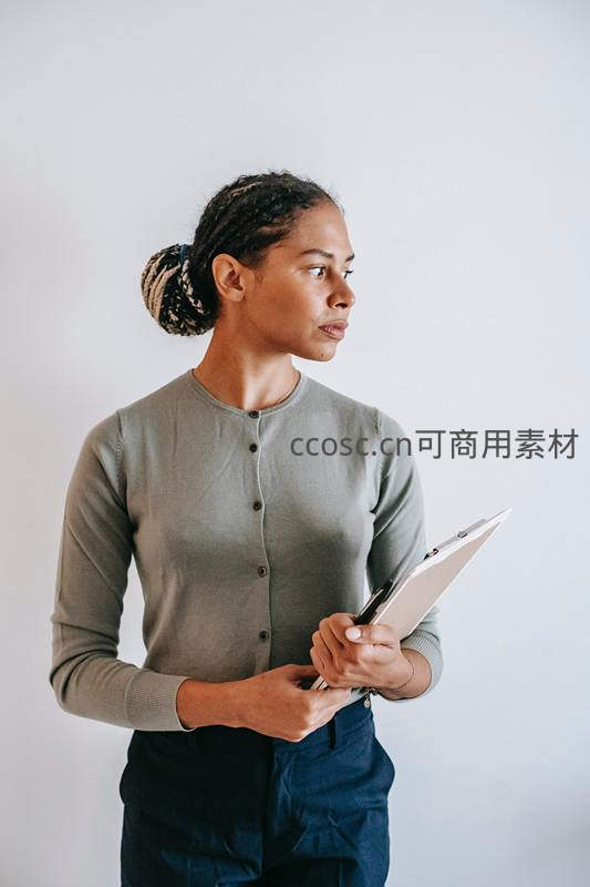 女性手持剪贴板侧身凝视