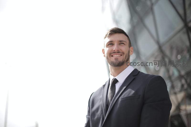 阳光下西装男士仰望微笑显自信
