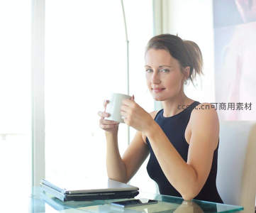 职场女性窗边品咖啡望向镜头