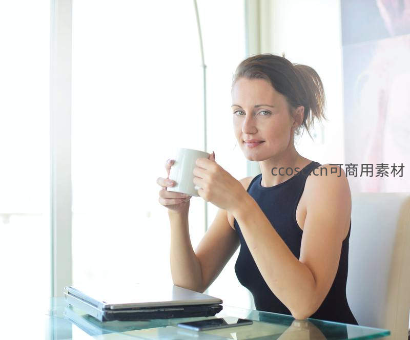 职场女性窗边品咖啡望向镜头