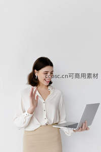 微笑女子手持电脑挥手致意