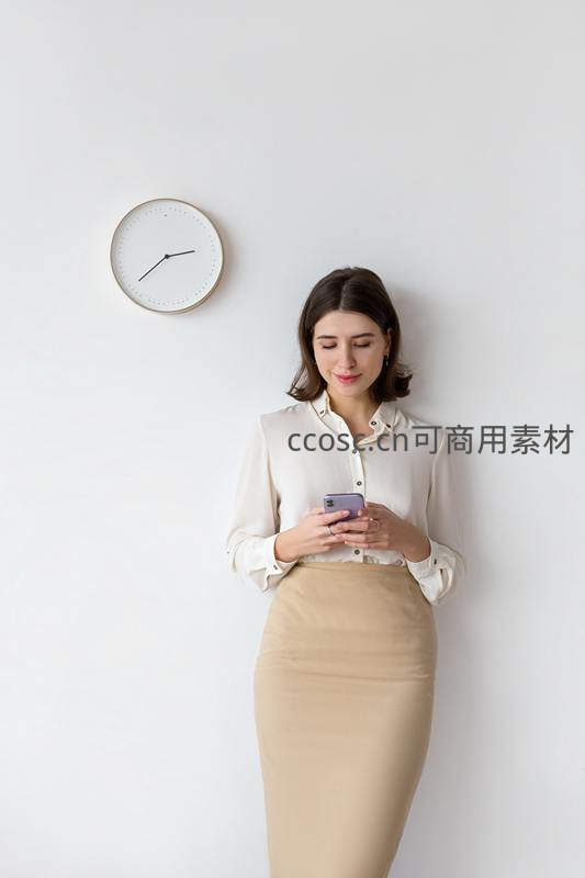 女子靠墙专注浏览手机