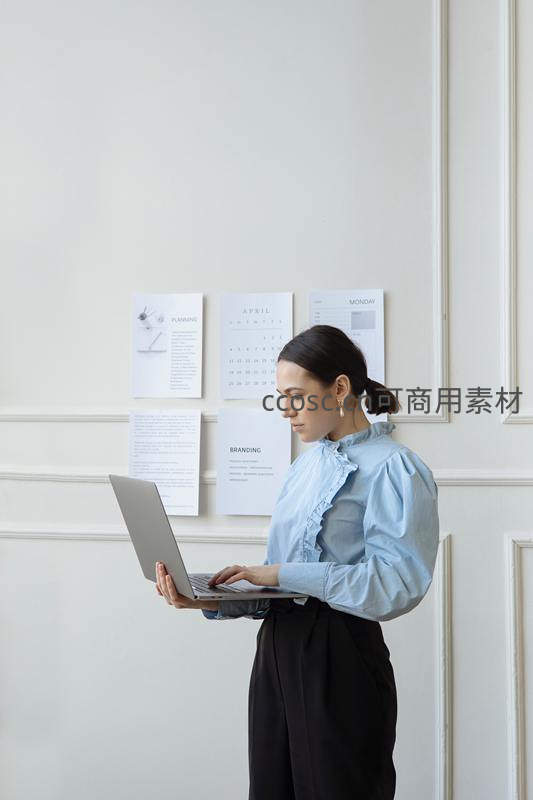 女士手持笔记本电脑专注办公