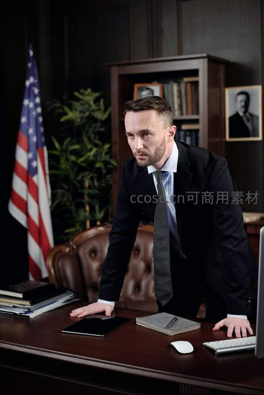 律师俯身办公桌审视文件