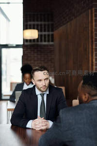 西装男士在咖啡馆内专注地与人对话