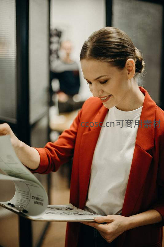女职员专注翻阅文件夹中的报告
