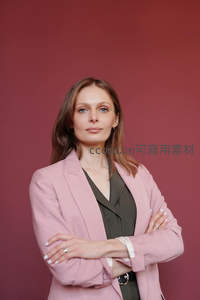 自信女性双臂交叉站立于红色背景前