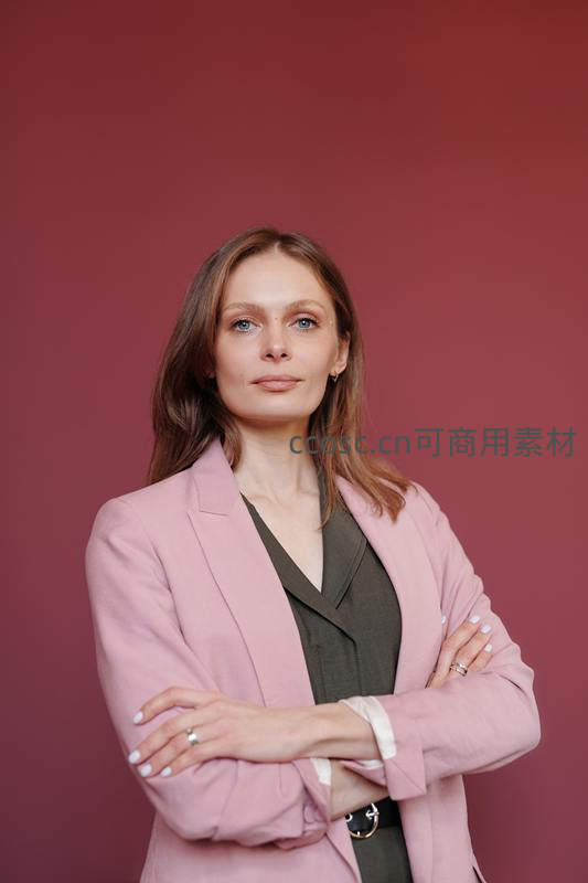 自信女性双臂交叉站立于红色背景前