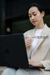 职场女性户外专注使用黑色笔记本电脑