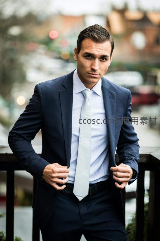 英俊男士整理西装凝视镜头