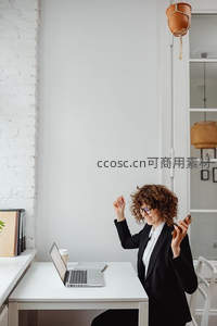 职场女性在办公桌前庆祝成功时刻