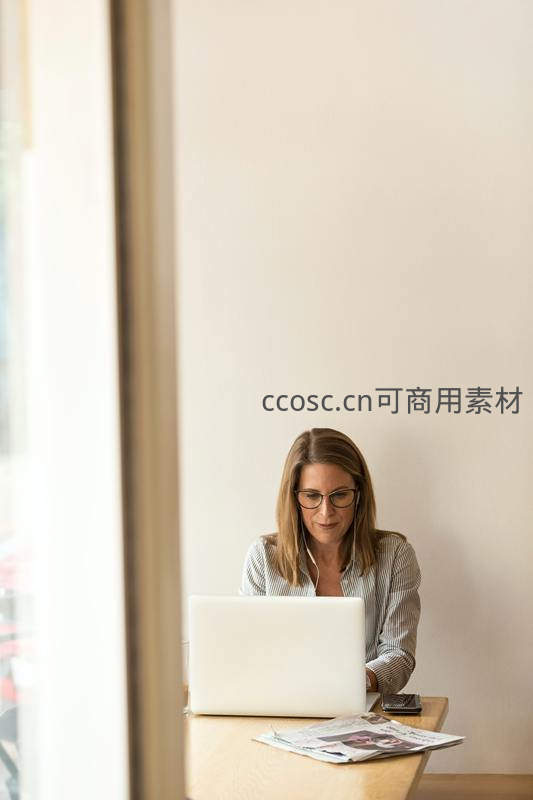 女士窗边使用笔记本电脑