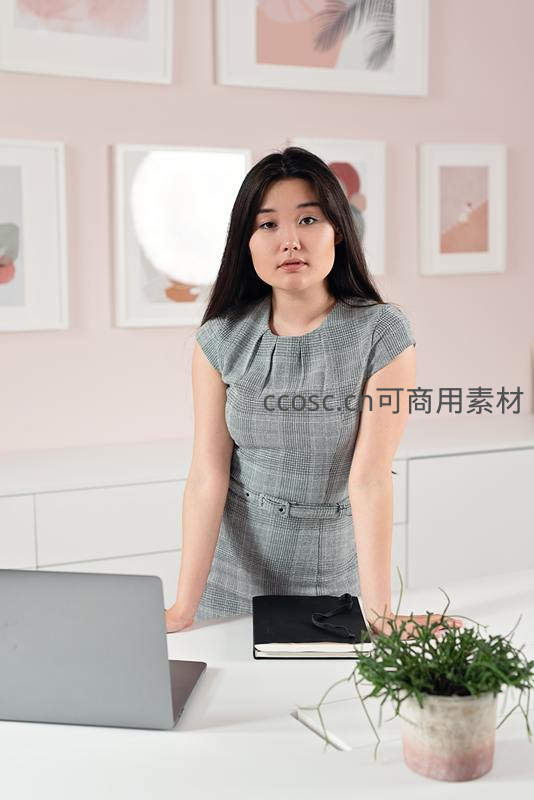 职场女性站立办公桌前凝视前方