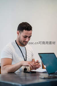 专注工作的年轻男性在办公桌前记录笔记
