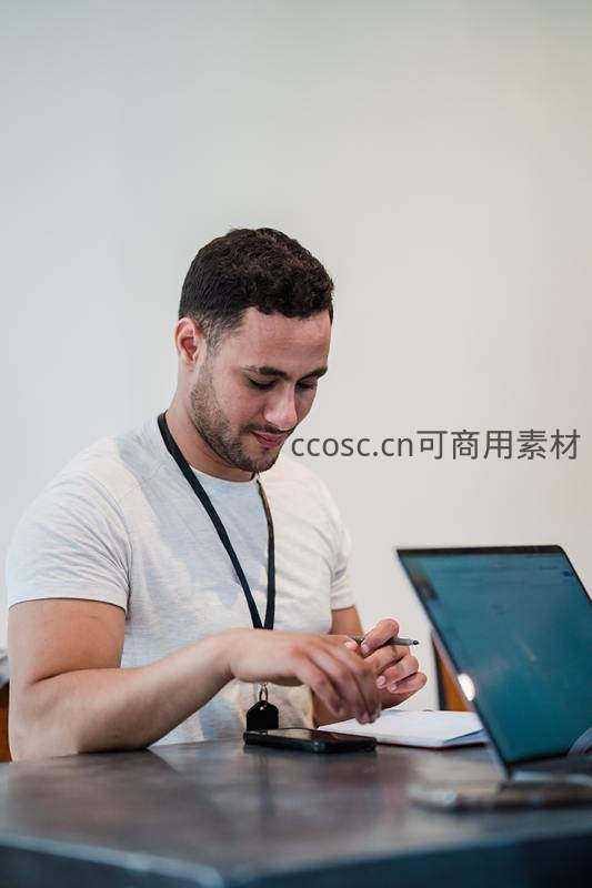 专注工作的年轻男性在办公桌前记录笔记