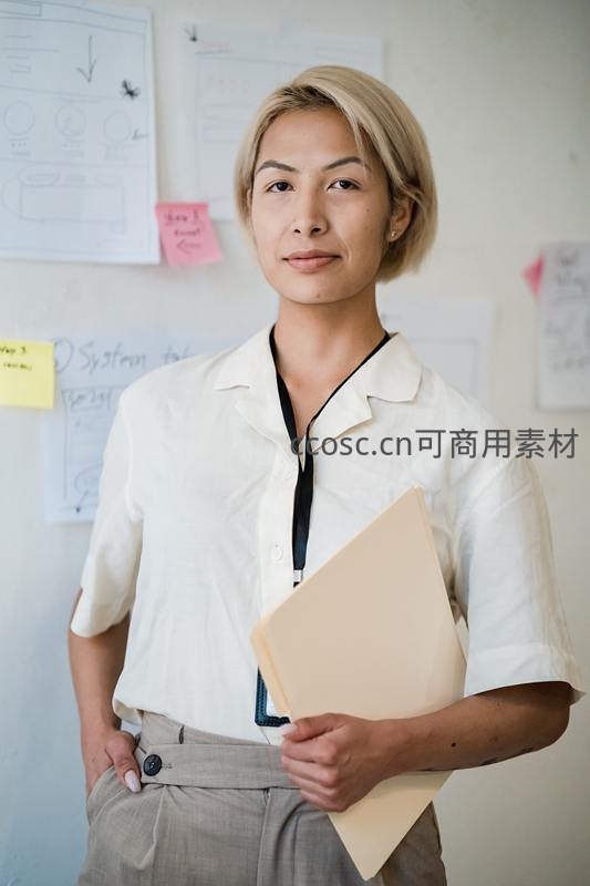 自信微笑的职场女性手持文件夹站立