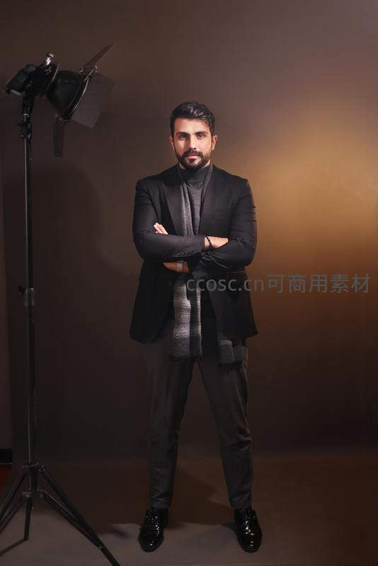 摄影棚内自信的绅士双臂交叉