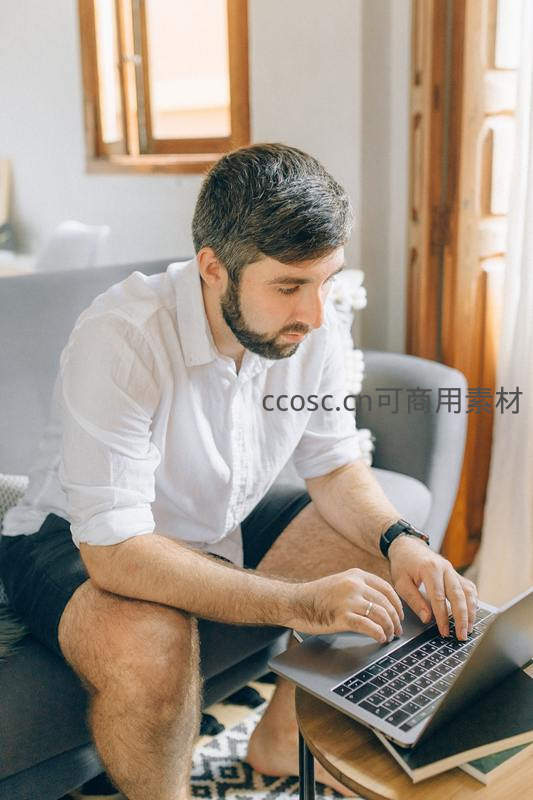 居家男子专注使用笔记本电脑