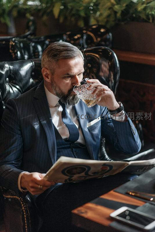 阅读报纸品味美酒
