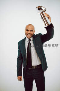 西装男子高举奖杯笑容灿烂