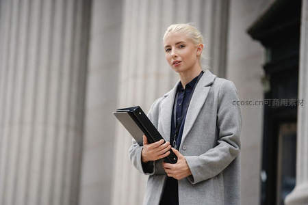 金发女律师手持文件夹仰望思考