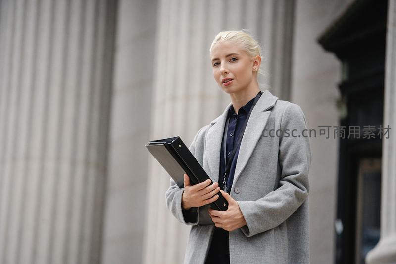 金发女律师手持文件夹仰望思考