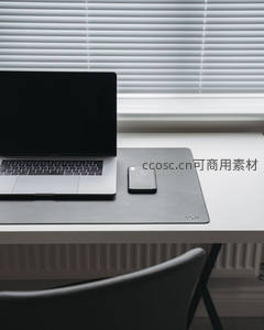 灰色鼠标垫上的静谧办公，笔记本与手机待命窗边