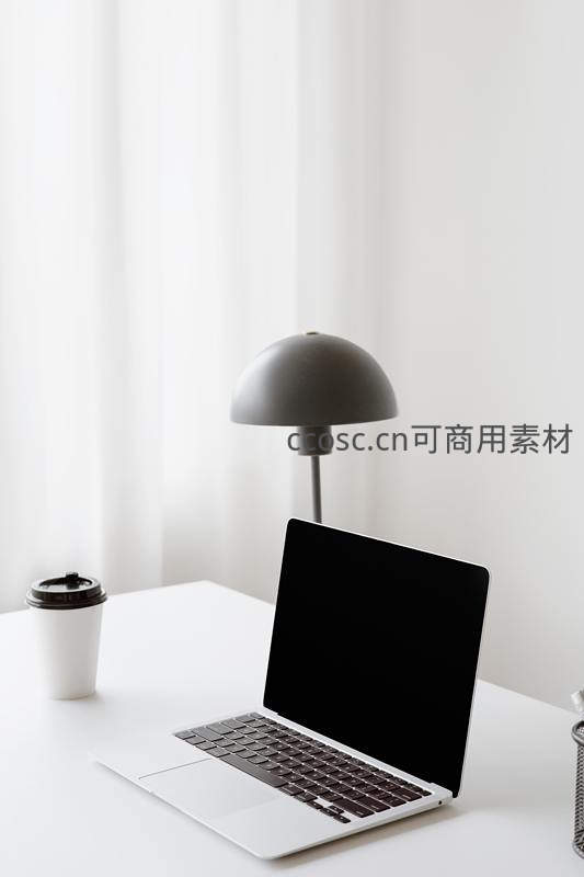咖啡与台灯相伴的极简办公桌面