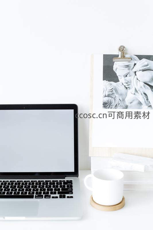 简约白色办公桌上的笔记本电脑与艺术装饰