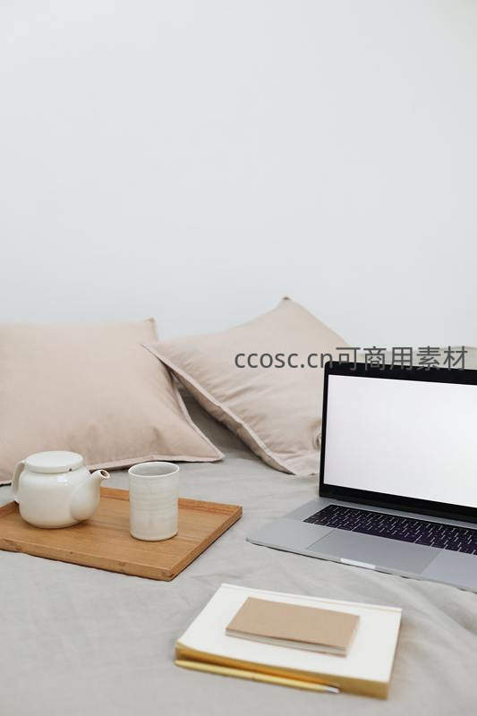 床榻上的笔记本与茶具静物