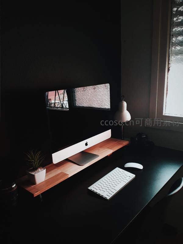 暗调光影中的极简电脑工作站