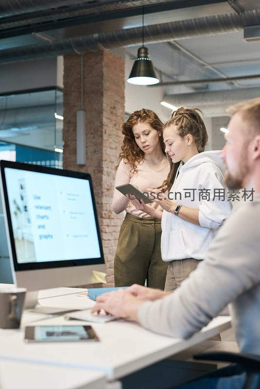 同事协作讨论数据，专注投入项目分析