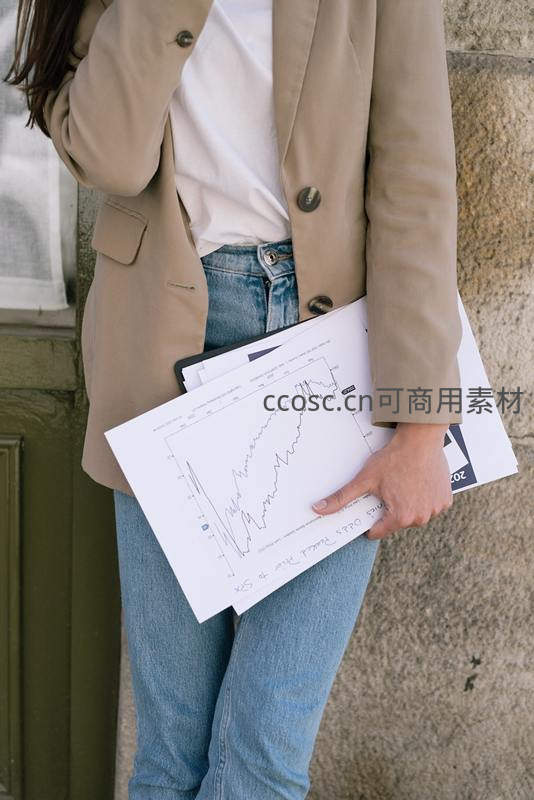 商务人士手持经济趋势报告文件