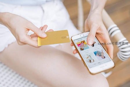 手持金卡与手机进行移动支付