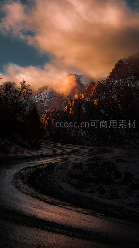 蜿蜒山路穿雪谷，夕照云霞染峰峦