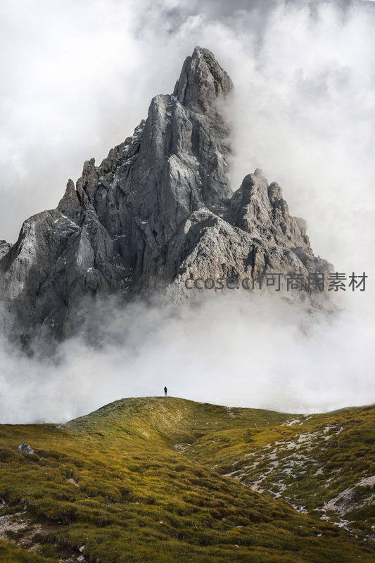 云雾缭绕尖峰耸立，绿坡孤影显渺小