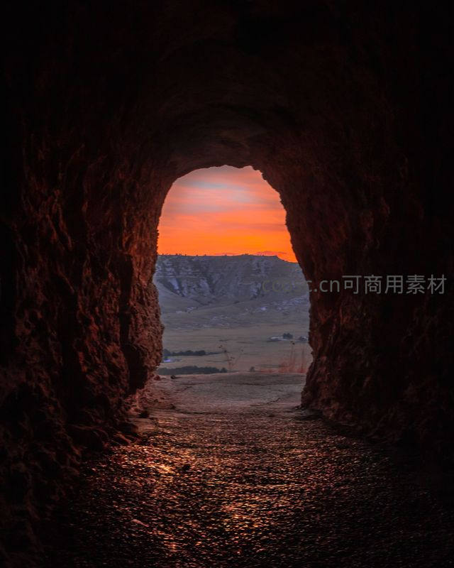 洞穴尽头的壮丽日落与远方山峦