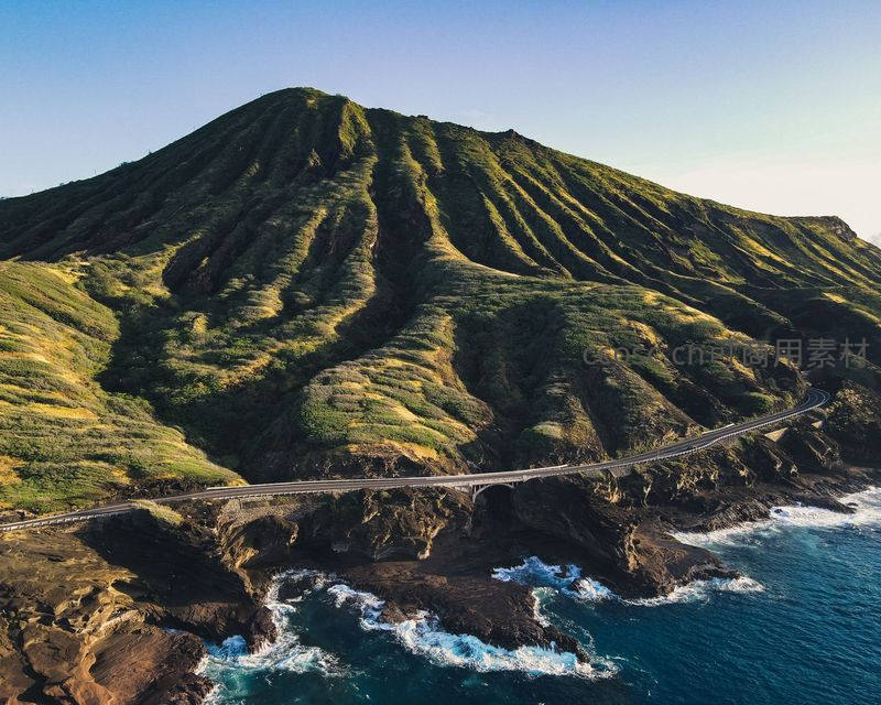 航拍视角下沿海公路蜿蜒于青山碧海间