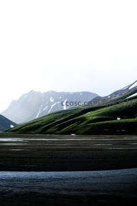 冰岛黑沙滩与远山雪景的静谧对望