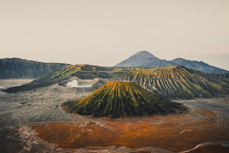 火山群落晨光映照，层叠山体如大地纹理