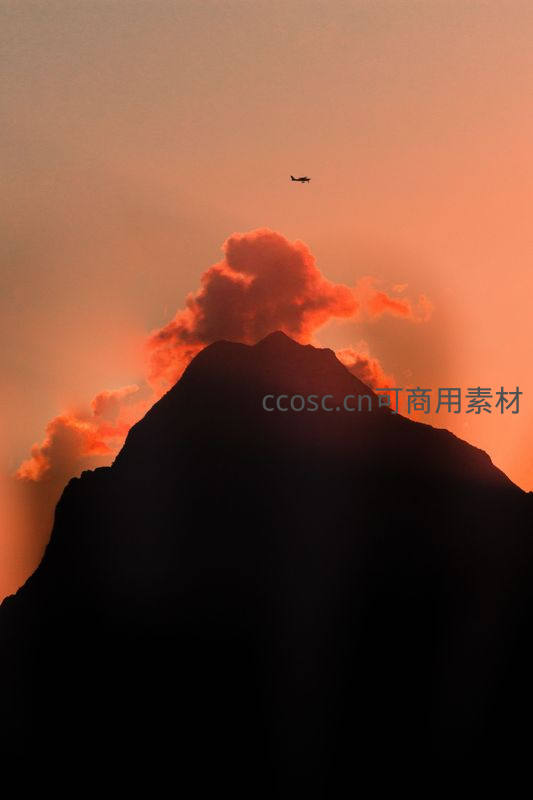 夕阳山巅飞机掠过云霞