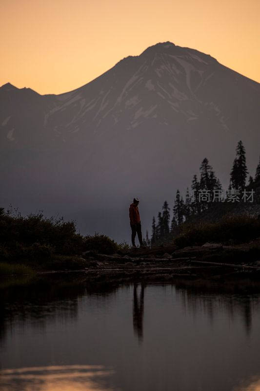 孤影伫立湖畔仰望雪山