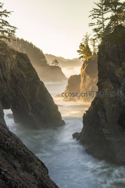 海岸岩壁间奔涌的海浪与晨曦