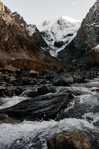 峡谷激流穿石而过，远山雪峰巍峨耸立